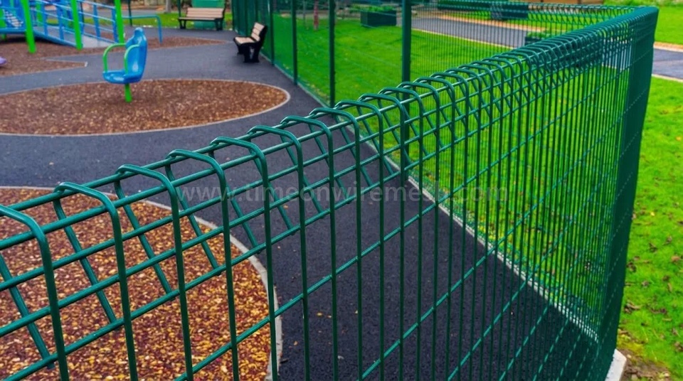 Full view of green Roll-Top welded mesh fencing around a playground